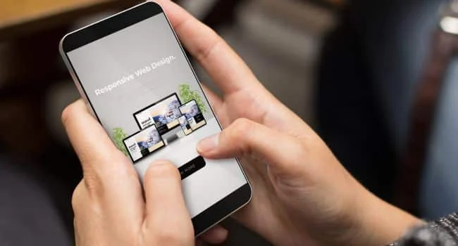 pessoa segurando um celular e navegando em um site responsivo